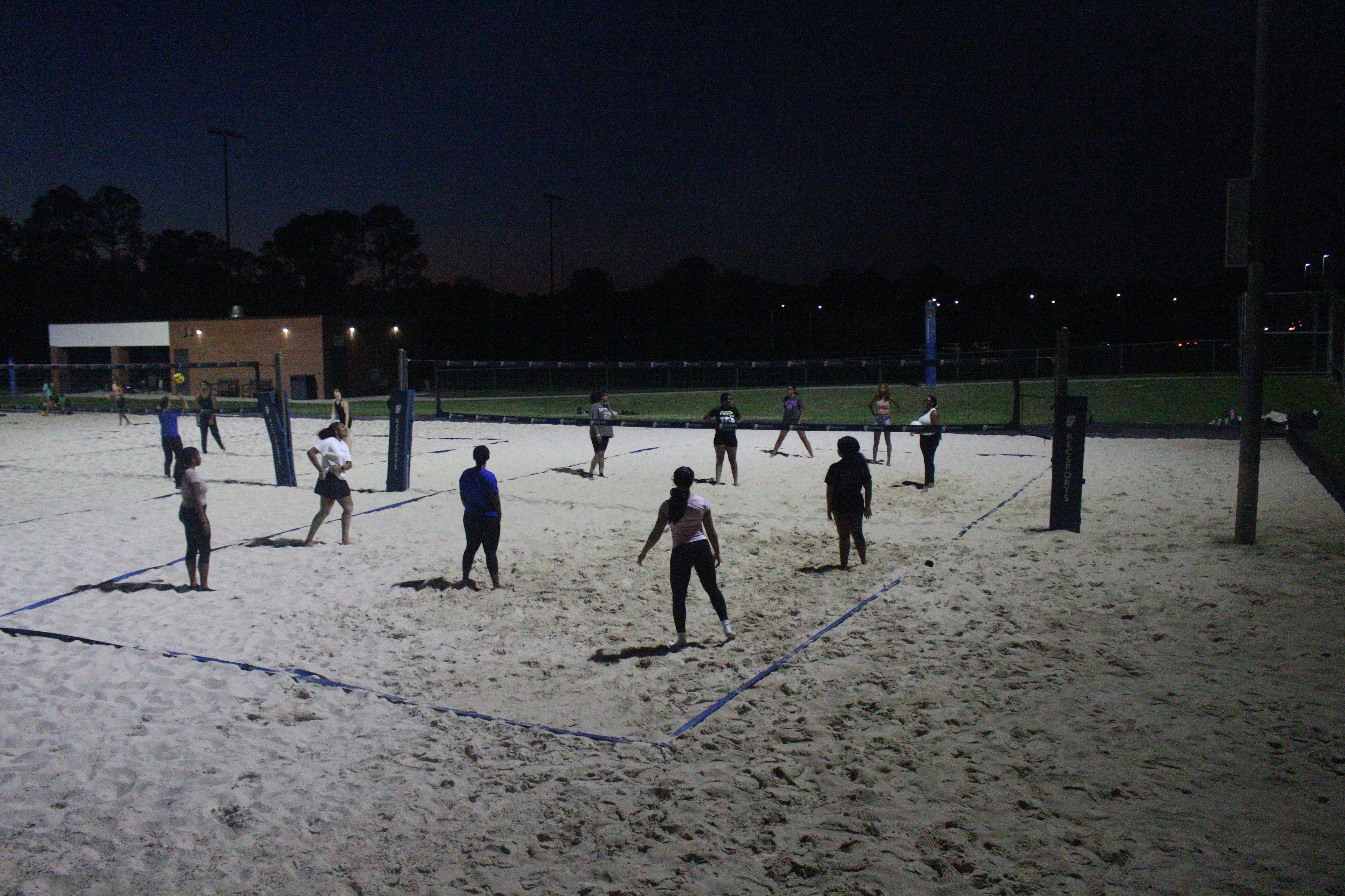 Members playing beach volleyball at a social event